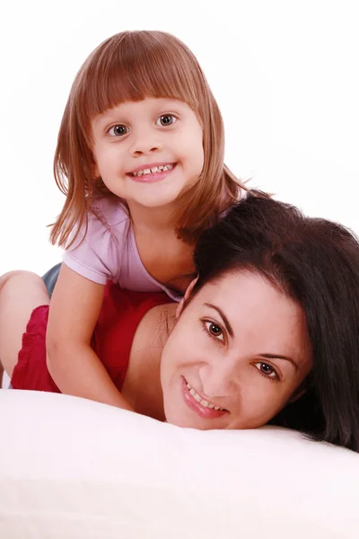 A portrait of a mother and her baby girl lying on the bed and sm — Stock Photo, Image