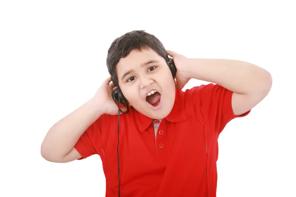 Portrait of a sweet young boy listening to music on headphones a — Stock Photo, Image