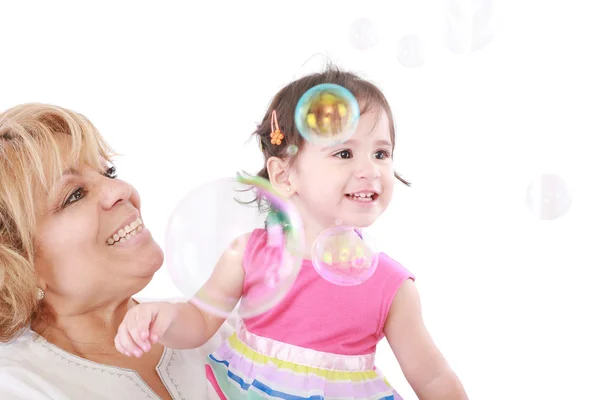 Teta a holčička si při pohledu na bubliny plovoucí v — Stock fotografie