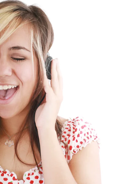 Bella bruna casual sta ascoltando musica su sfondo bianco — Foto Stock