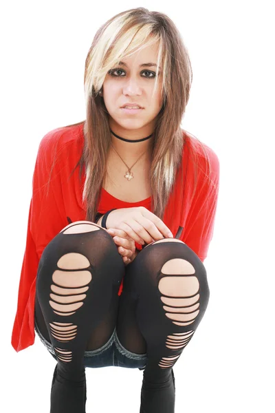 Jovem mulher de traje punk se dobra para abraçar as pernas enquanto olha — Fotografia de Stock