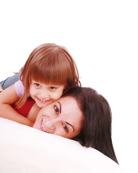 Junge Mutter und Tochter umarmen sich auf dem Bett Stockbild