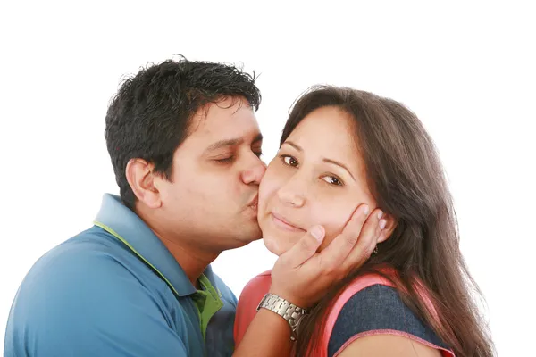 Portrait of woman looking at camera with man near by kissing her — Stock Photo, Image