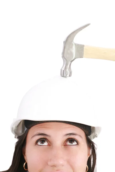 Ragazza con casco di sicurezza che sta per essere colpita da un martello su un bianco — Foto Stock