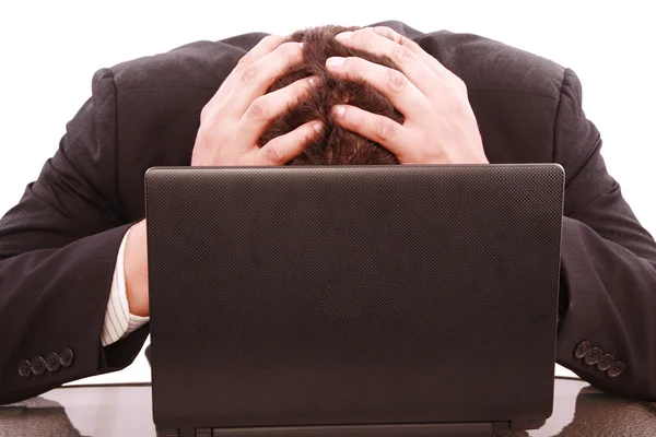 Un homme d'affaires prospère est frustré sur une table avec un ordinateur portable — Photo