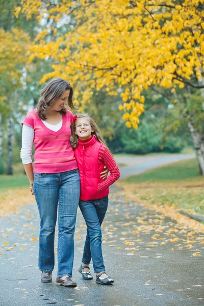 Nettes Mädchen mit ihrer Mutter, die im Park spazieren geht — Stockfoto