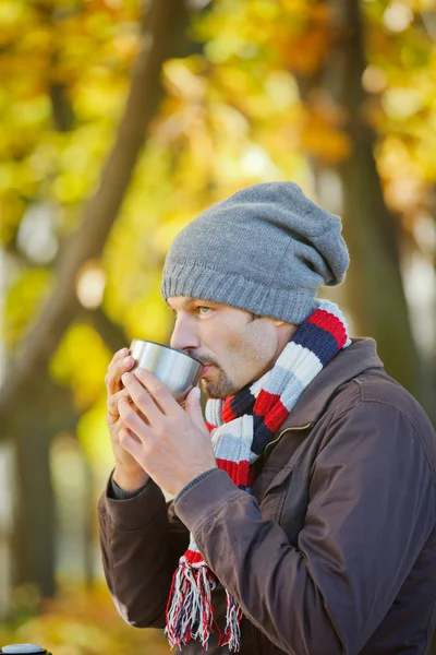 Homem bebe chá no parque de outono — Fotografia de Stock