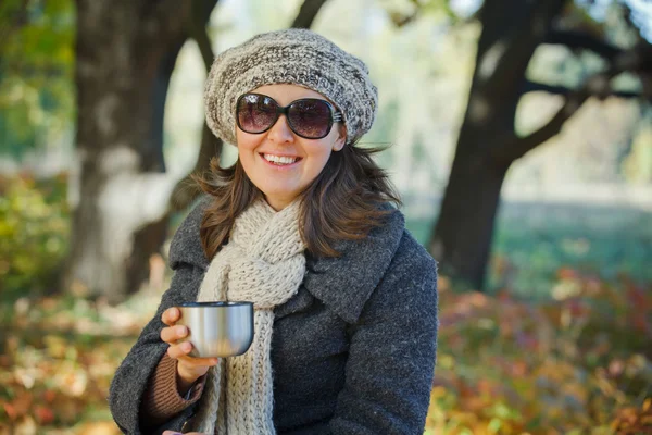女人在秋天公园喝茶 — 图库照片