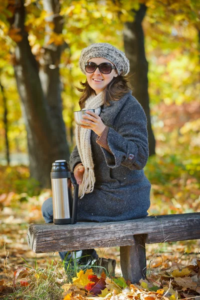 Γυναίκα που πίνει τσάι στο πάρκο φθινόπωρο — Φωτογραφία Αρχείου