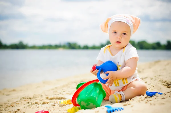 Klein schattig meisje op het strand — Stockfoto
