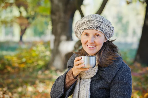 Femeia bea ceai în parcul de toamnă — Fotografie, imagine de stoc