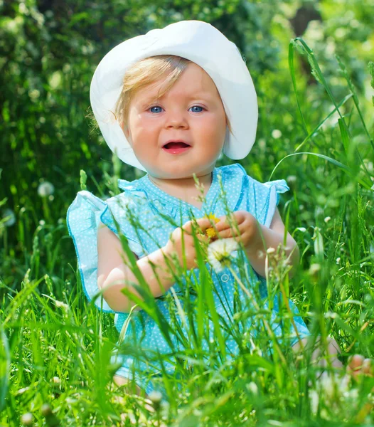 Kleines Mädchen sitzt im Gras im Park — Stockfoto