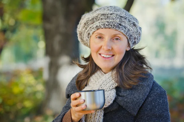 秋の公園で茶を飲む女性 — ストック写真
