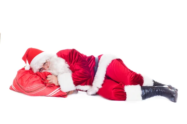 Weihnachtsmann ruht auf der Tasche mit Geschenken. — Stockfoto