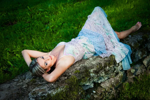 Attraktiv kvinna liggande på stenar — Stockfoto