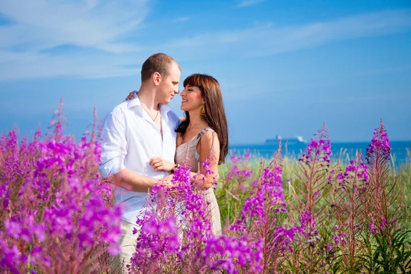 Romace entre flores púrpuras cerca del mar azul —  Fotos de Stock