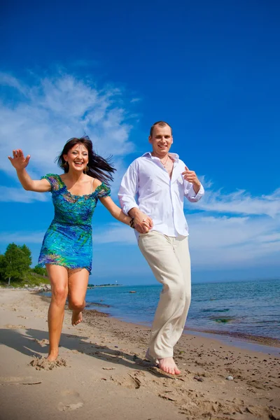 Zakochana para biegnie wzdłuż wybrzeża Morza — Zdjęcie stockowe