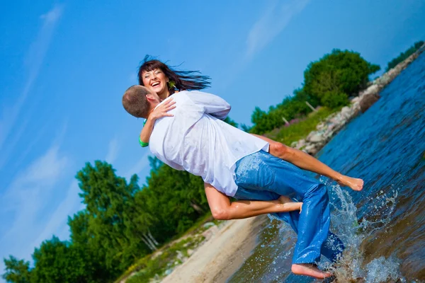 Förälskad par embracing på sunny beach — Stockfoto