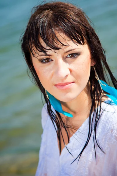 Porträtt av vackra brunett tjej med blött hår nära blå havet — Stockfoto
