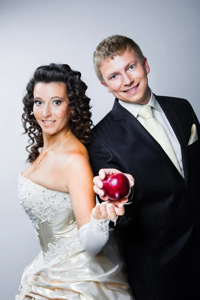 Noivo tomando maçã vermelha de noiva bonita jovem — Fotografia de Stock