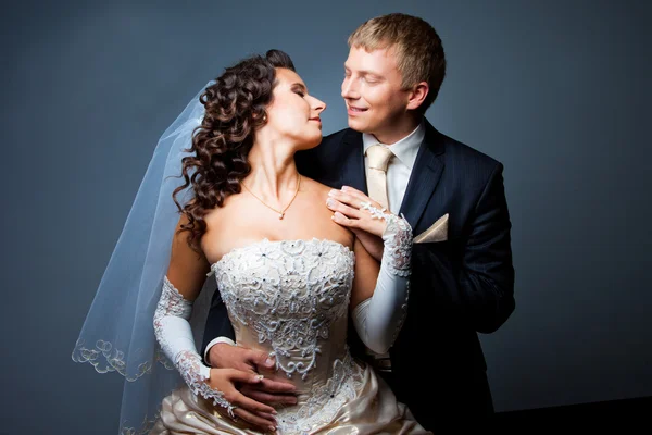 Bruid en bruidegom omarmen en kijken naar elkaar — Stockfoto