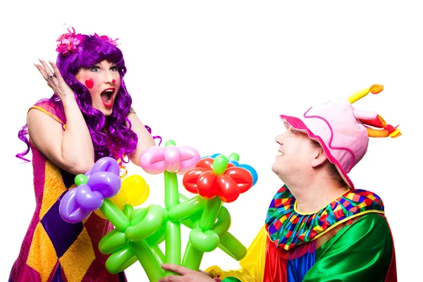 Любящие клоуны с разноцветными цветами — стоковое фото