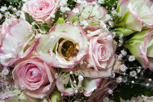 Anneaux de mariage sur bouquet de mariée — Photo