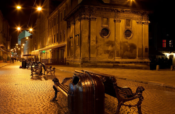 Lviv street by night with old church and many lanterns
