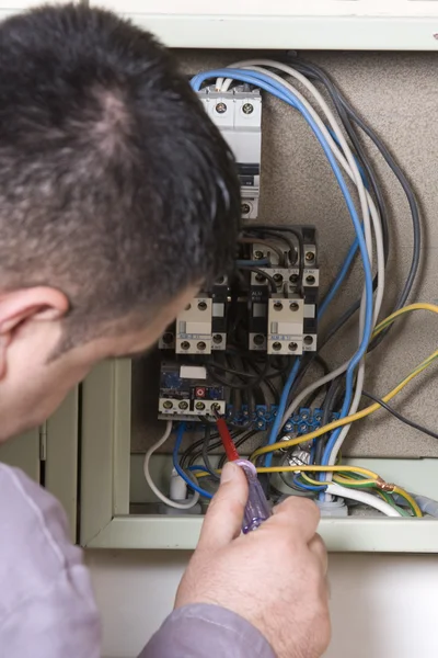 Electricista trabajando en un panel — Foto de Stock