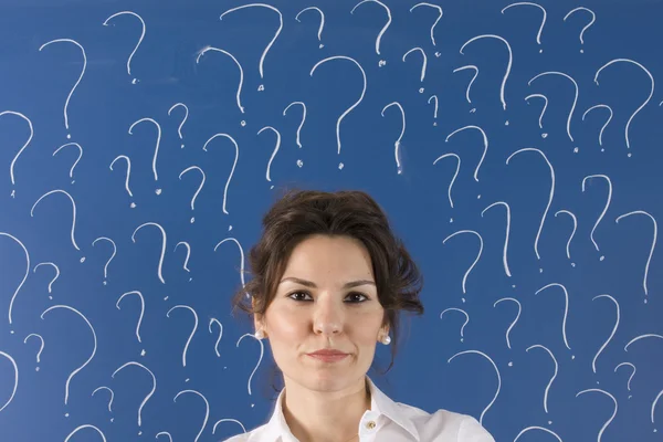 Denkende Geschäftsfrau vor Fragezeichen — Stockfoto