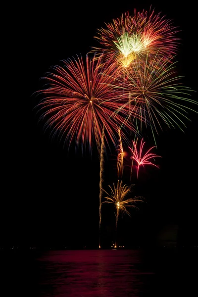 stock image Beautiful fireworks on black sky with reflections in lake