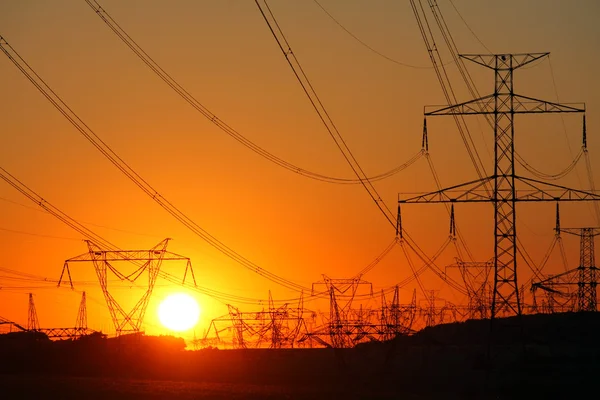 Transmission towers at orange sunset — Stock Photo, Image