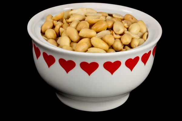 Peanuts in a heart bowl — Stock Photo, Image