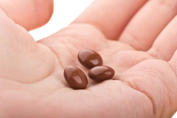 Los comprimidos son de color marrón en la mano — Foto de Stock