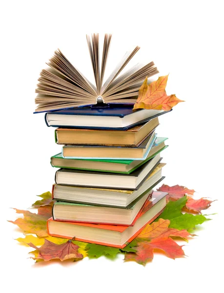 Livre ouvert sur une pile de livres à gros plan et feuilles d'érable d'automne sur — Photo