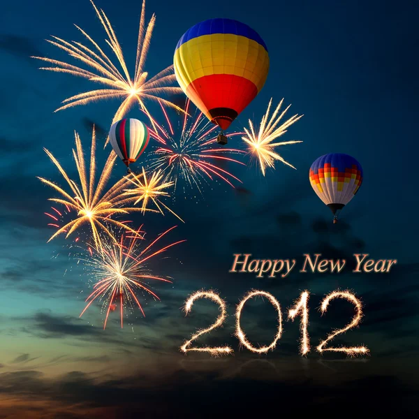 Ohňostroj na nový rok 2012 a hot balónu při západu slunce — Stock fotografie