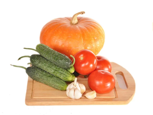 Grönsaker på en styrelse och en pumpa — Stockfoto