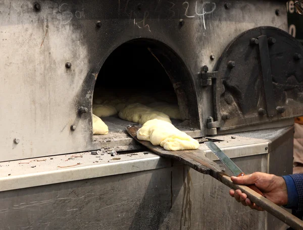 Brød er blevet bagt i en ovn på en træpalle - Stock-foto