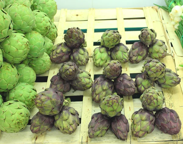 Bunches of fresh artichokes on a market stall — Stock Photo, Image