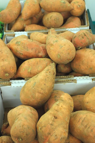 Fresh sweet potatoes on a market stall — Stock Photo, Image