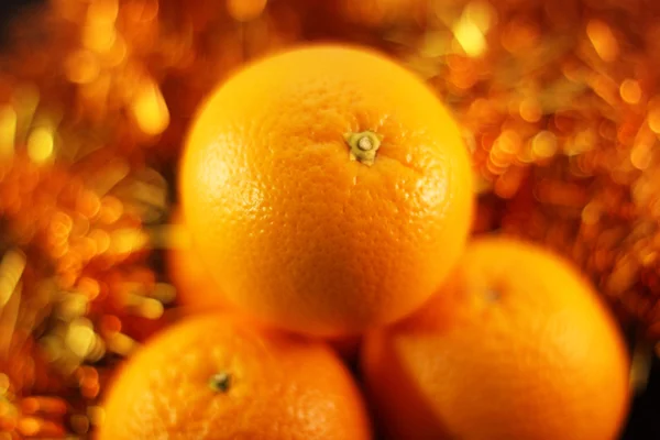 Orange close up on a background of twinkling garlands — Stock Photo, Image