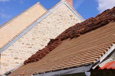 Renovation of a tiled roof of an old house clipart