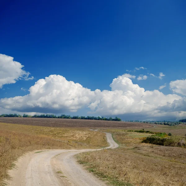 Estrada rural sob céu nublado dramático — Fotografia de Stock