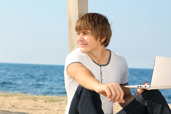 Όμορφος νεαρός στην παραλία κοιτάζοντας μακριά — Stock fotografie