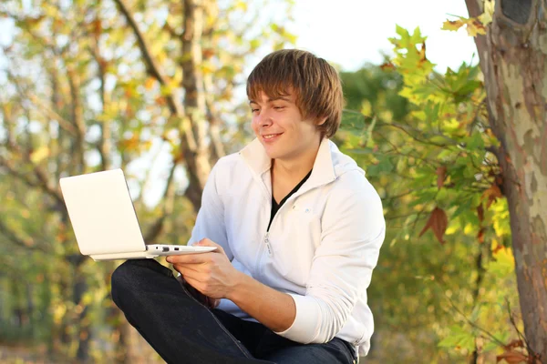 Happy man travail à l'ordinateur portable, en plein air automne — Photo