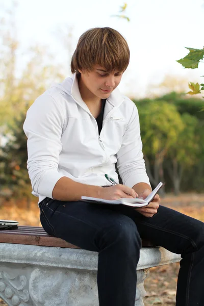 Νεαρός άνδρας γράφουν ποίηση, φθινόπωρο σε εξωτερικούς χώρους — Φωτογραφία Αρχείου