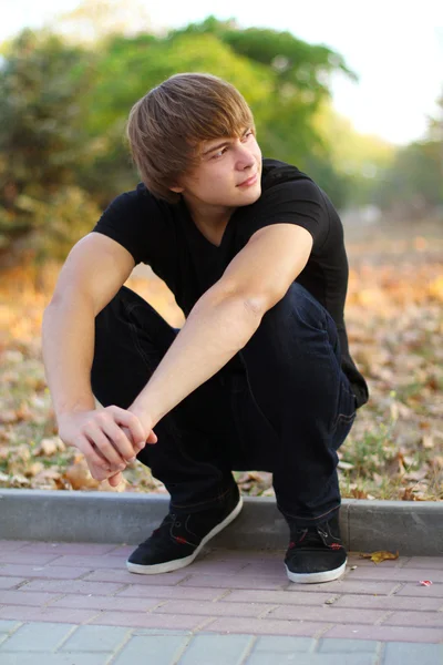 Genç adam, öğrenci açık havada, sonbahar park bak — Stok fotoğraf