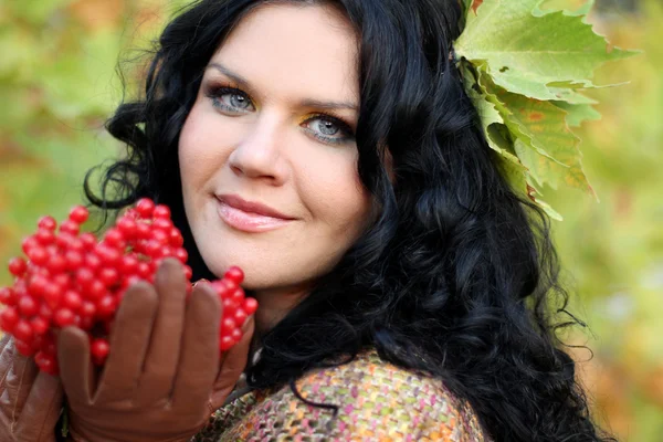 Portrét zblízka ženy s červenými plody, přes zelenou přírodou — Stock fotografie