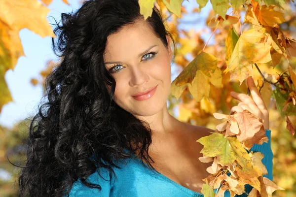 Zblízka portrétní usmívající se žena v podzimní listí venku — Stock fotografie