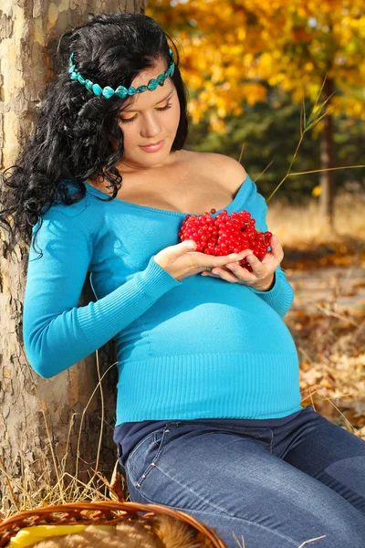 Hermosa mujer embarazada con flecha roja de madera, otoño al aire libre —  Fotos de Stock